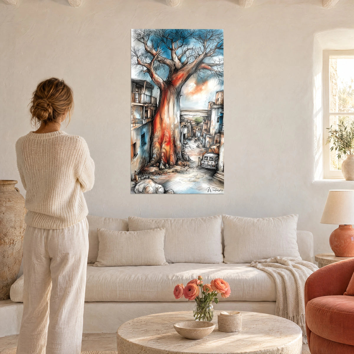 Gemälde Riesen-Baobab mit rotorangefarbenem Stamm, türkisblauer Himmel, eine Frau von hinten über einem Sofa in einem hellen Wohnzimmer