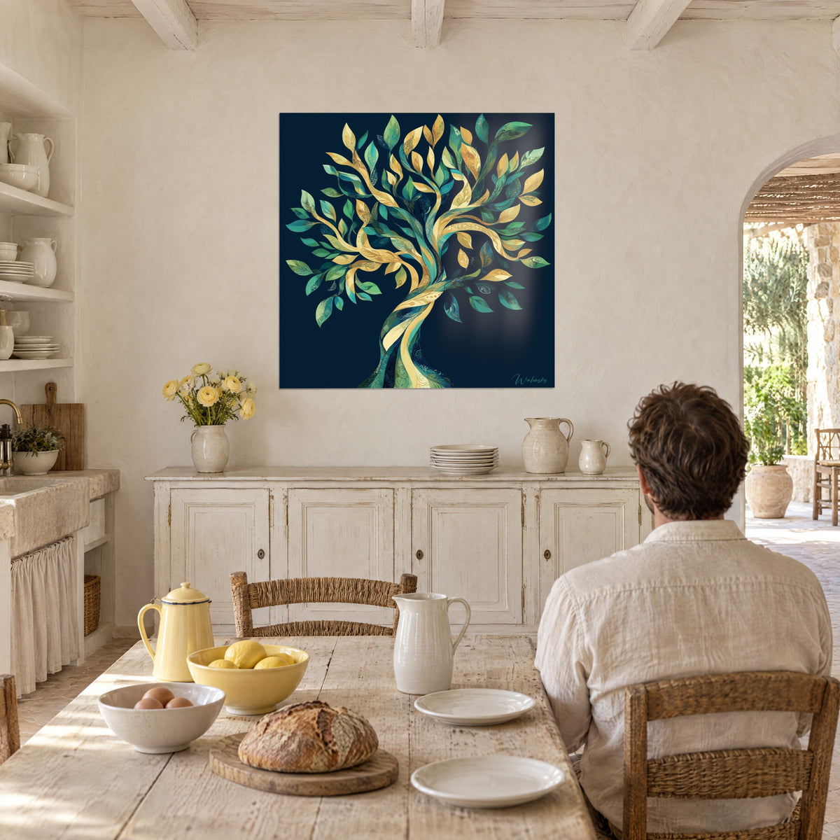 Cuadro tronco en espiral y follaje en oro, verde y turquesa, hombre de espaldas a la mesa junto al pan y los limones, comedor provenzal
