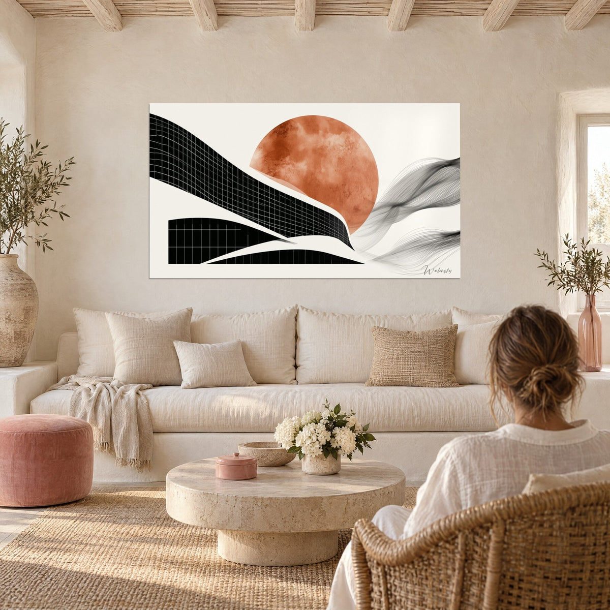 Tableau soleil terracotta derrière un bâtiment courbe noir quadrillé, fond crème, au-dessus d'un canapé dans un salon lumineux
