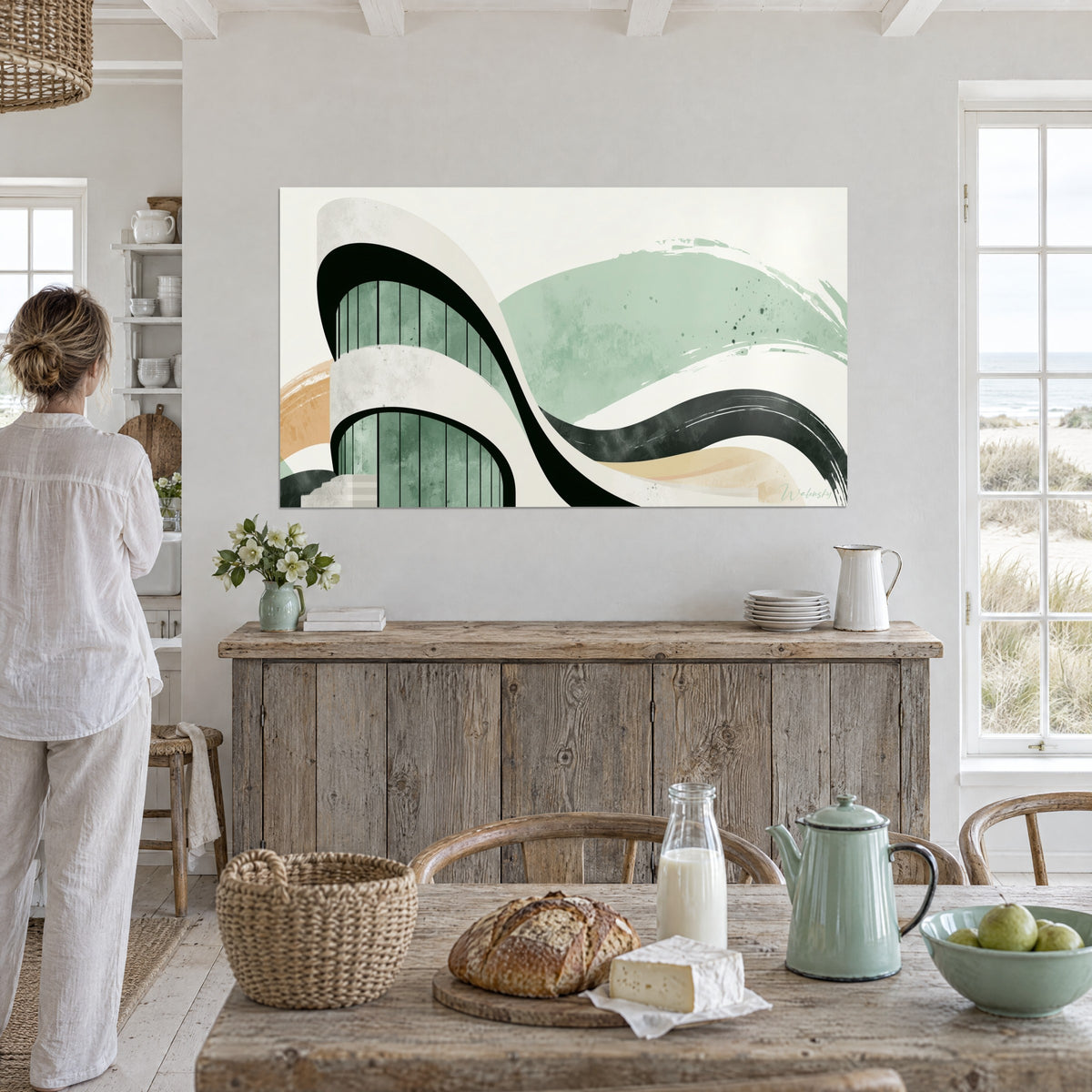 Tableau volutes d'architecture anthracite et blanc cassé, fond vert sauge moucheté, face à un buffet en bois dans la maison de plage
