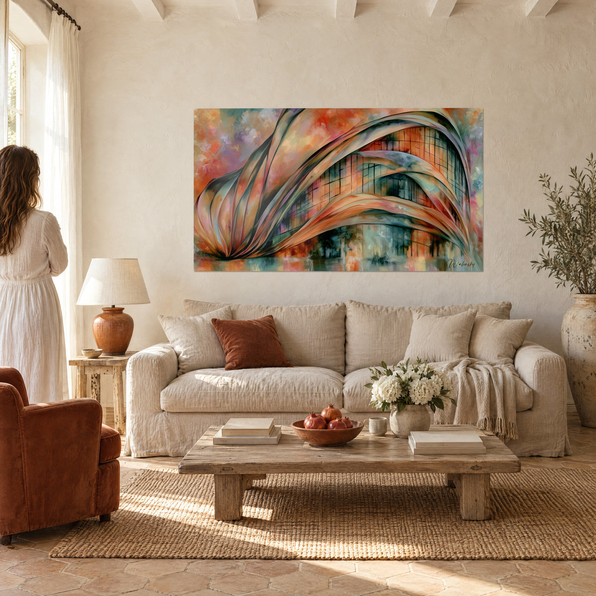 Tableau arches sculpturales orange et bleu sarcelle sur un mur crème, femme en robe blanche de dos, au-dessus d'un canapé dans un salon lumineux