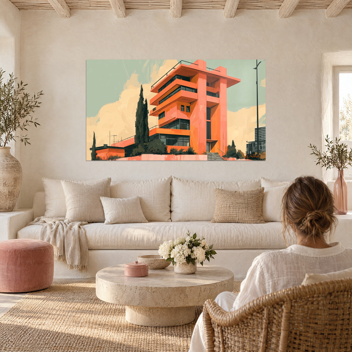 Wall art coral apartment block with stacked balconies, dark cypress and sage sky, hung above a sofa in a bright living room