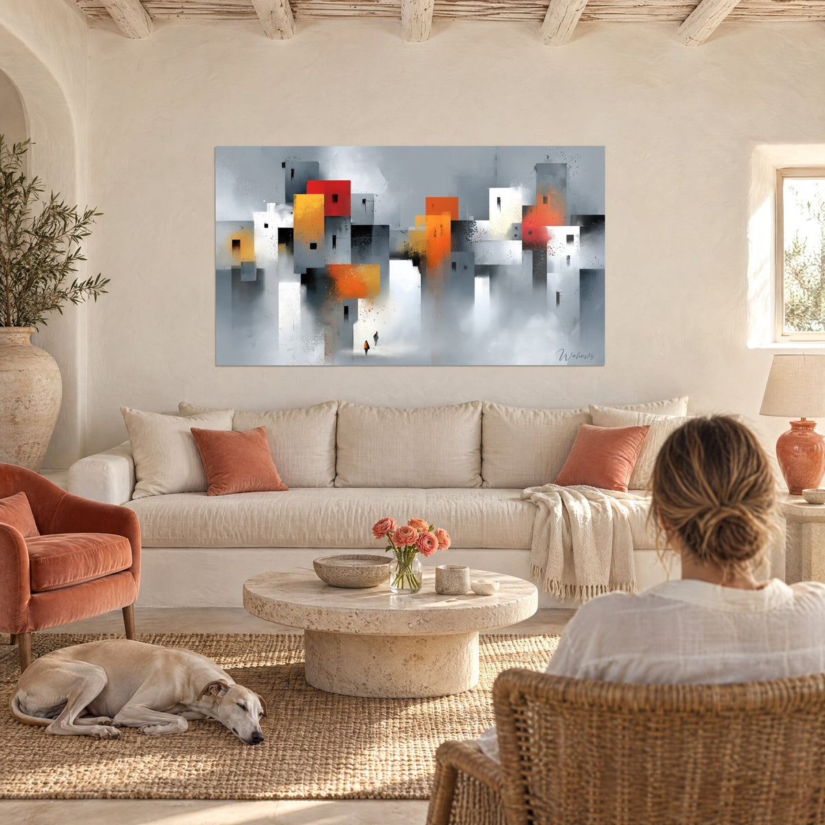 Tableau cité grise aux façades orange et rouges, deux silhouettes minuscules, au-dessus d'un canapé dans un salon lumineux