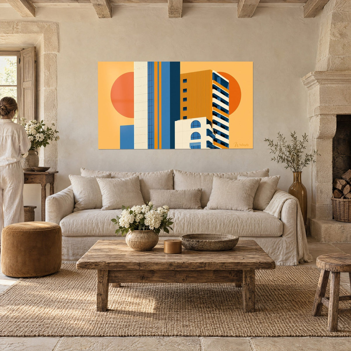 Quadro torre geometrica in ocra e blu navy davanti a un grande sole arancione, due sagome di spalle, sopra un divano in un soggiorno luminoso