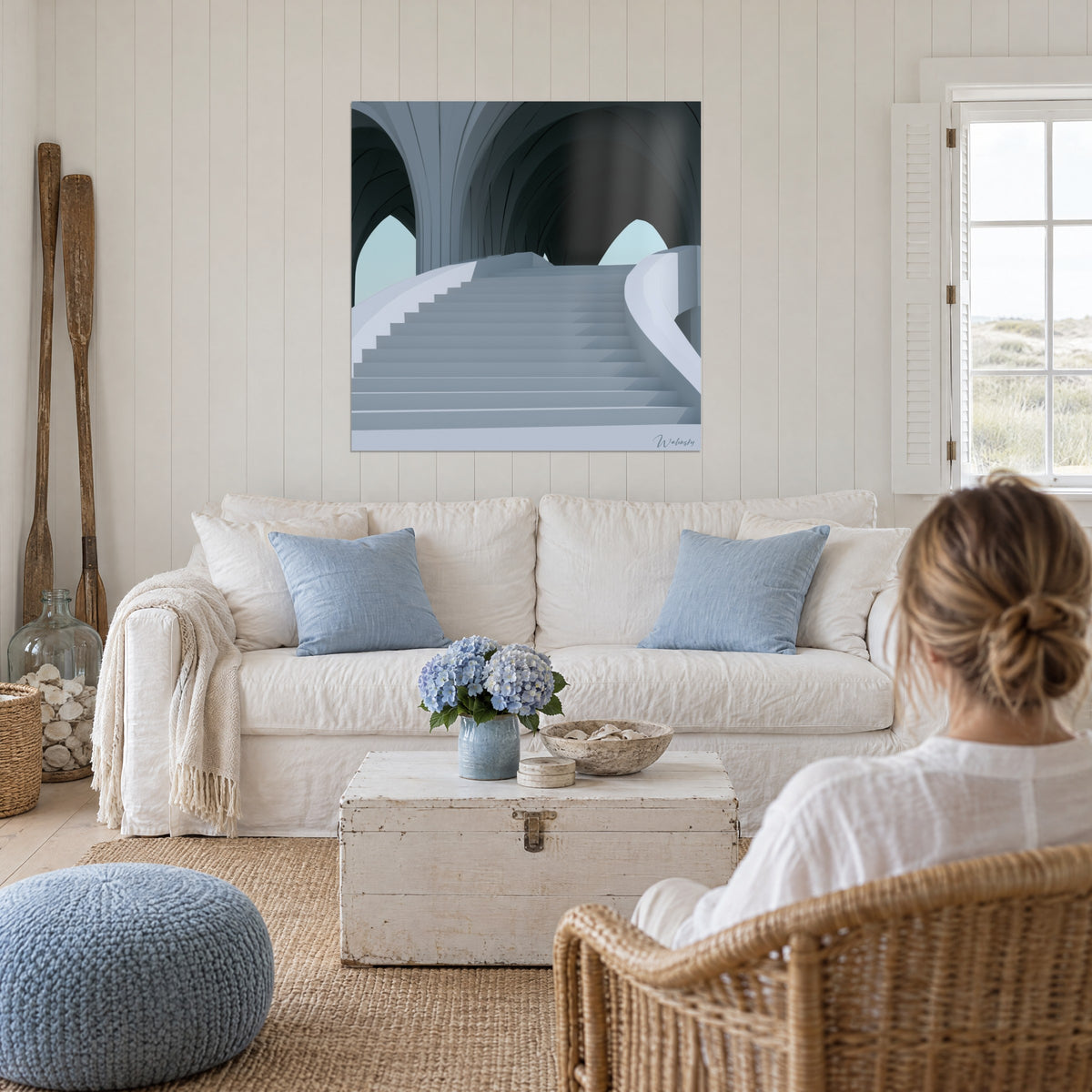 Tableau escalier blanc courbe sous arches anthracite, marches gris-bleu et ciel pâle, au-dessus d'un canapé dans un salon lumineux