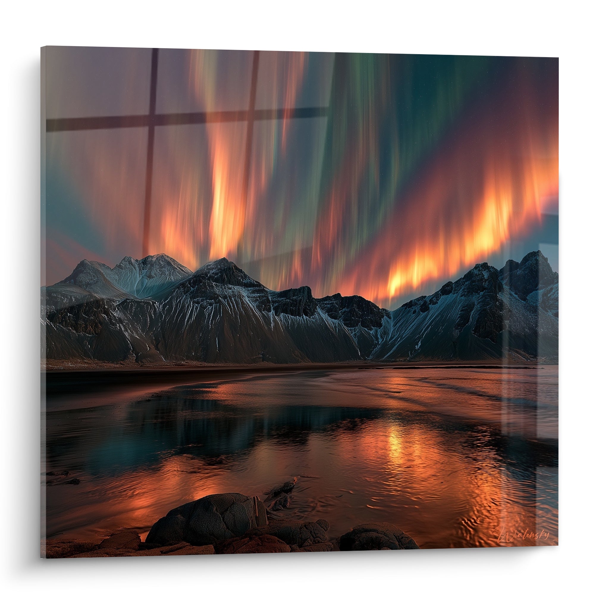 Aurore boréal orangée et verte illuminant des montagnes enneigées face à un lac calme