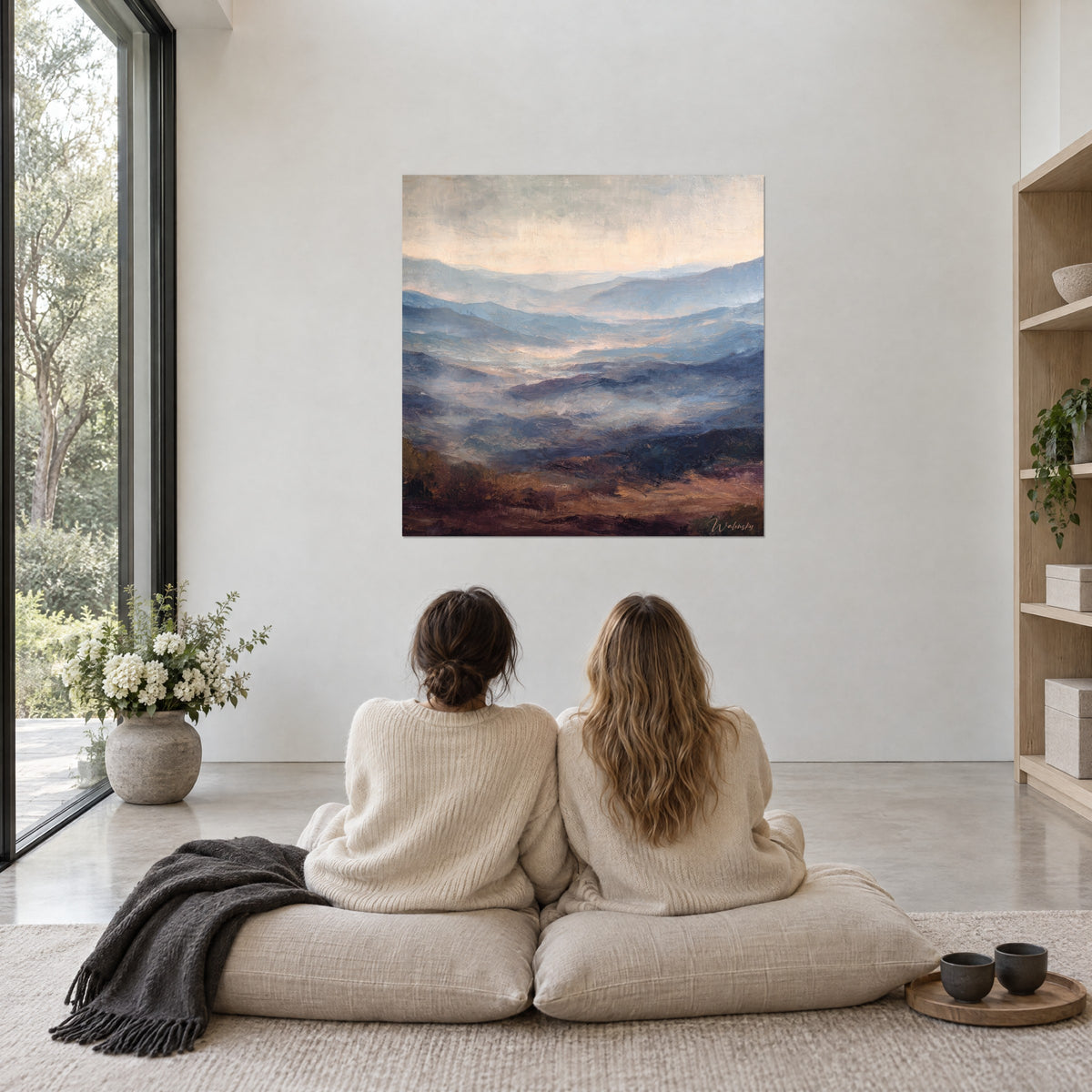 Wall art panorama of mist-veiled valleys, grey blue and plum, two women seen from behind seated on cream cushions