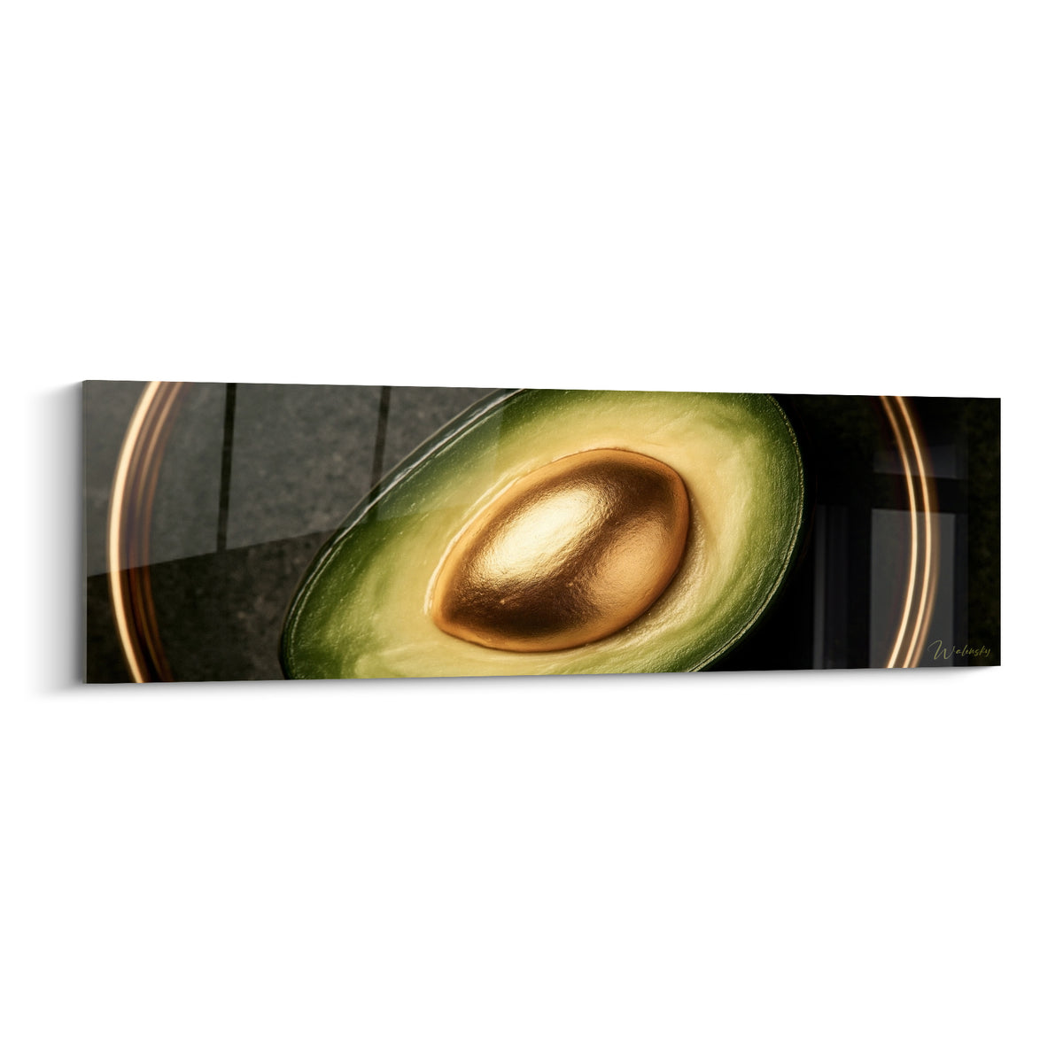 Avocat coupé au noyau doré brillant, chair vert olive sur fond anthracite sombre