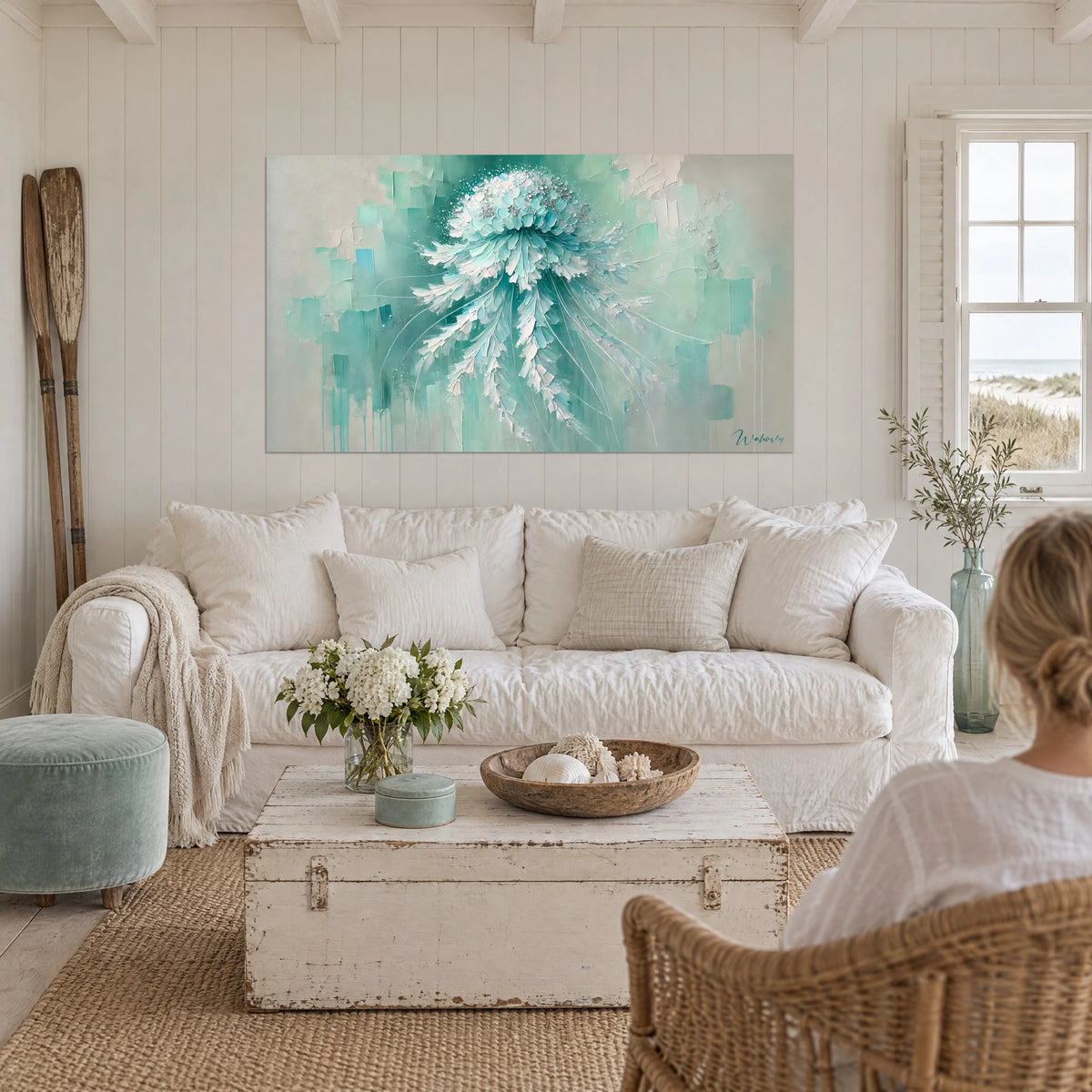 Wall art jellyfish in turquoise paste and pearly white, feather tentacles, two people seen from behind above a sofa in a bright living room