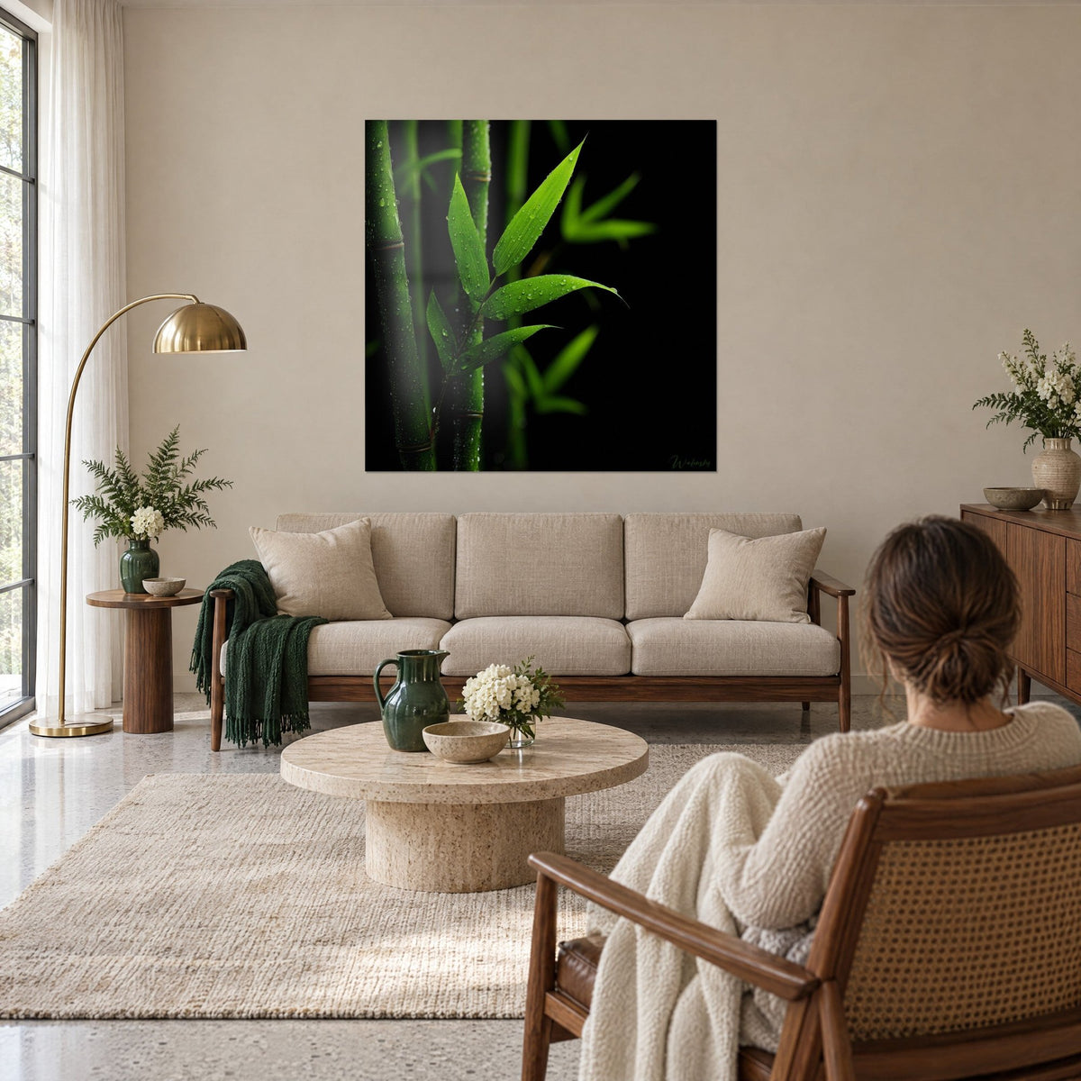 Quadro stelo di bambù con gocce di rugiada, foglie verde vivo su fondo nero, sopra un divano in un soggiorno luminoso
