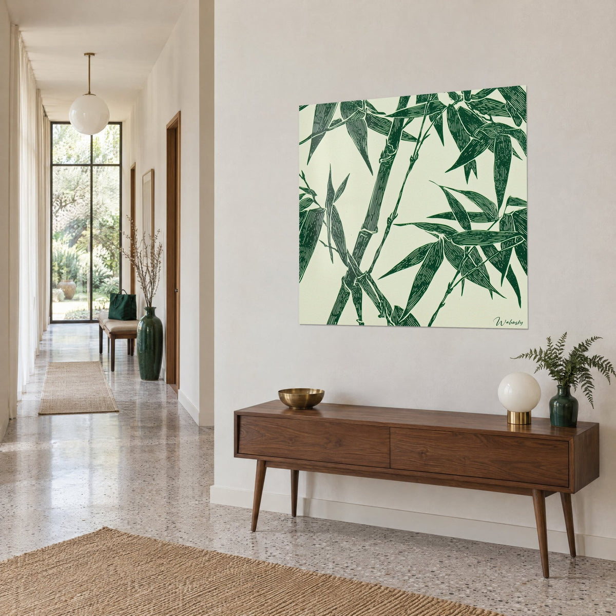 Quadro di steli di bambù intrecciati, fogliame verde abete su carta avorio, appeso sopra una credenza in legno in un corridoio