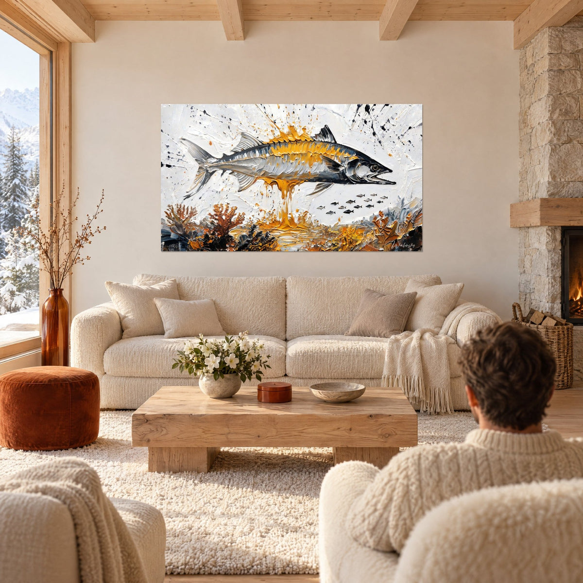 Wall art silver barracuda with golden flanks, white background splashed with black, person from behind above a sofa in a bright living room