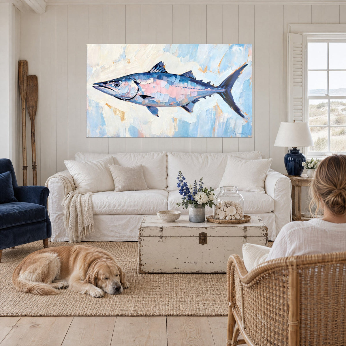 Wall art silver barracuda with blue and pink palette-knife strokes, navy fin, above a sofa in a bright living room