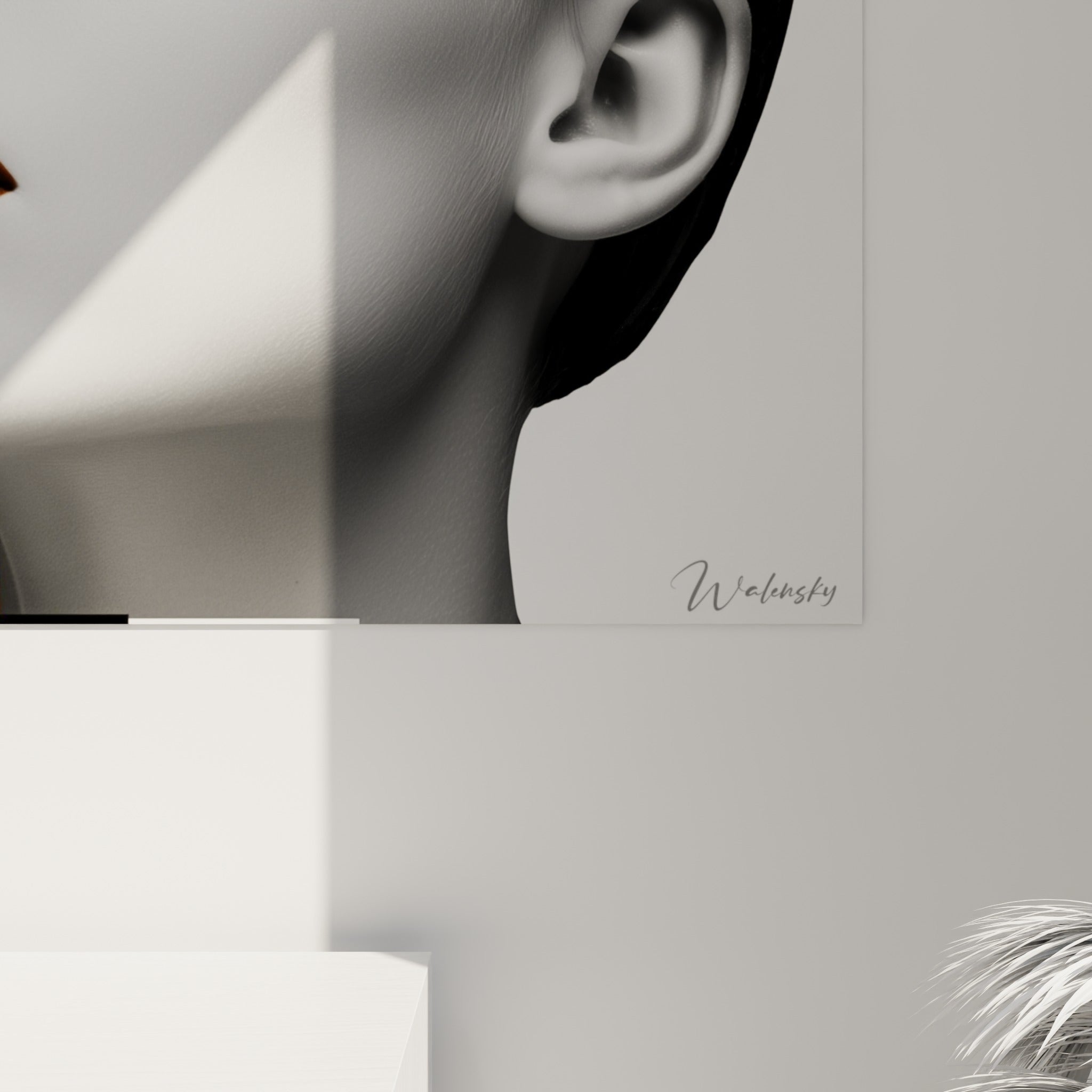 Détail de la bande orange lisse et du grain photographique du portrait noir et blanc accroché au mur