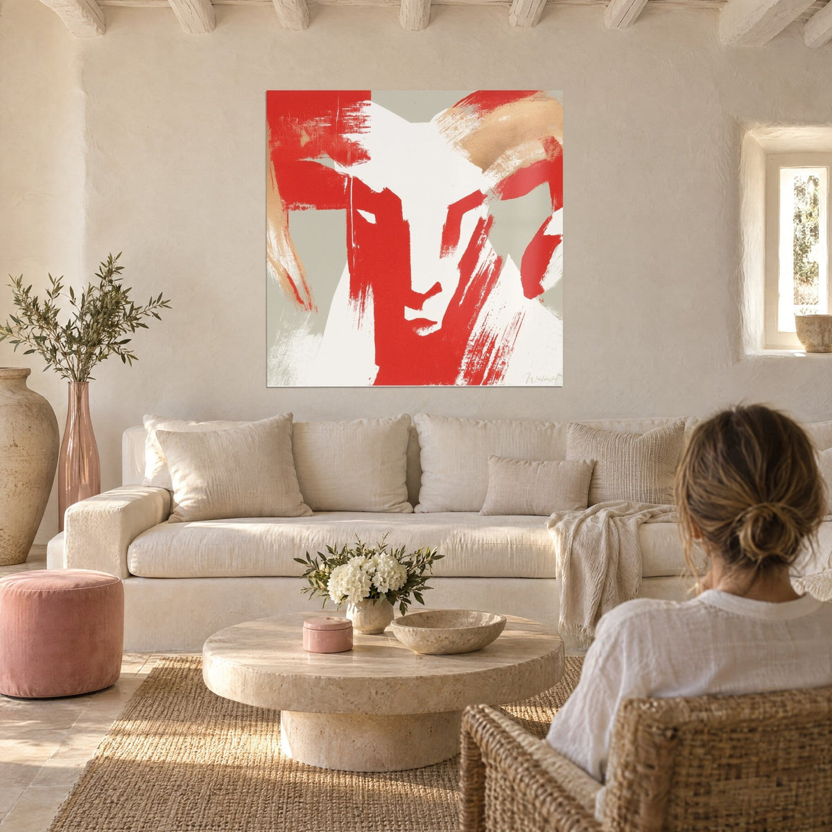 Tableau bélier stylisé aux traits rouge vif et cornes beige sable, face blanche, au-dessus d'un canapé dans un salon lumineux