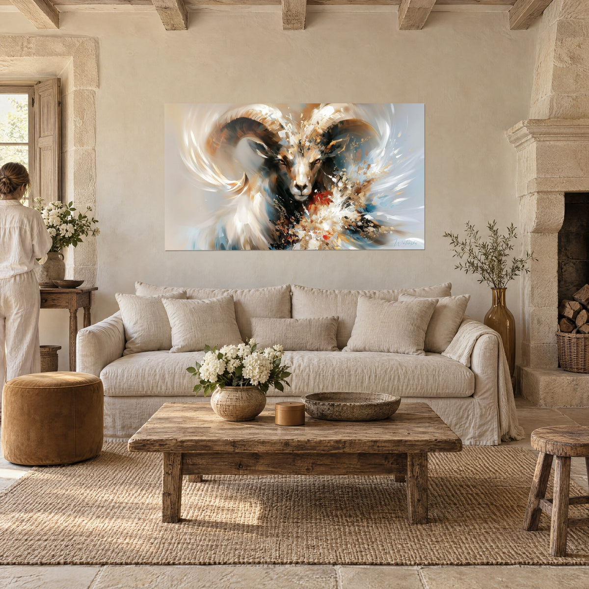Wall art ram with ivory and golden-brown horns, navy blue splashes, person seen from behind above a sofa in a bright living room