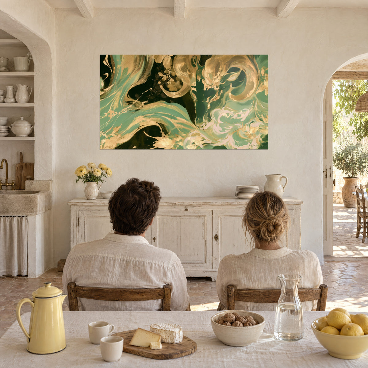 Wall art spirals of gold and green paint accented with pale pink, facing a couple seated at a table in a Provençal farmhouse