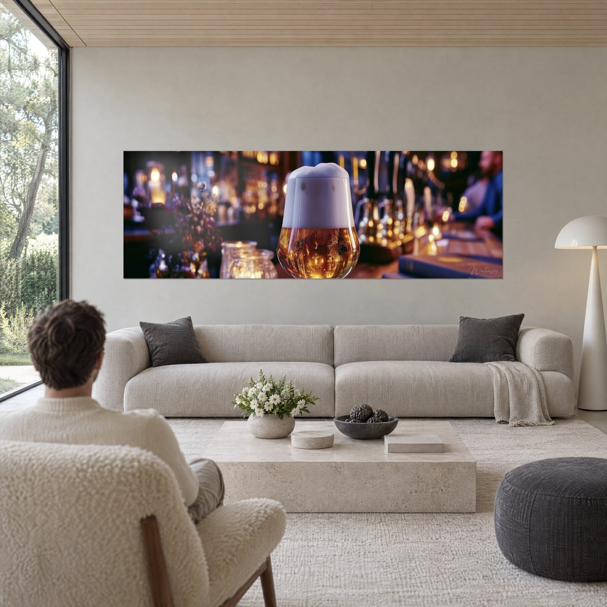 Gemälde mit bernsteinfarbenem und goldenem Schaumbier in einem Glas, verschwommene bläuliche Kerzen, über einem Sofa in einem hellen Wohnzimmer