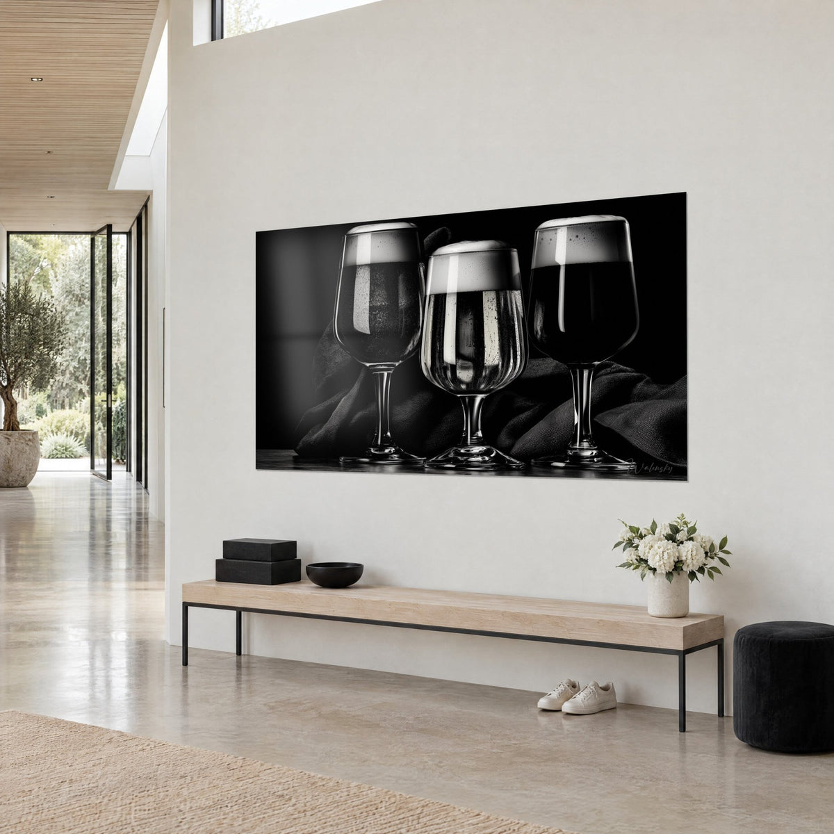 Tableau verres à bière tulipe en noir et blanc, mousse ivoire et reflets argent sur drap sombre, accroché sur un mur clair en trois-quarts