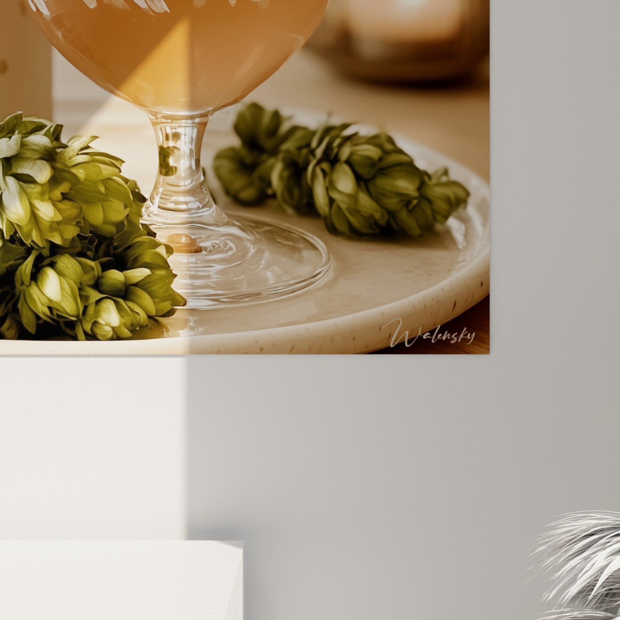 Détail rapproché du verre bière montrant la mousse blanche et le motif végétal peint