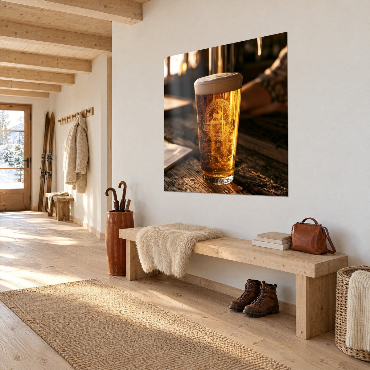Quadro bicchiere di birra bionda frizzante con stemma di cervo inciso, toni ambra e crema, su un muro bianco d'ingresso di chalet