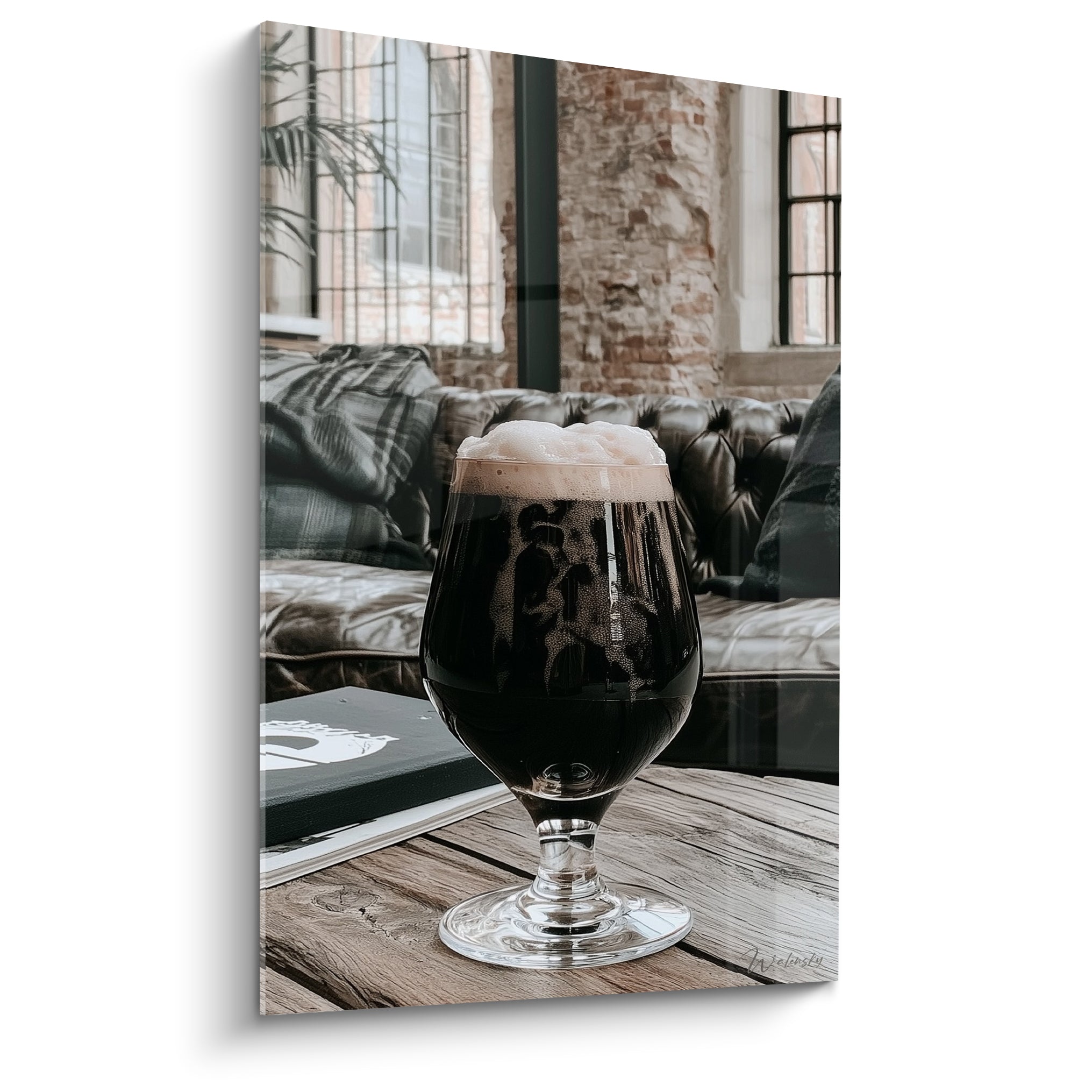 Verre de bière stout anthracite à mousse crème posé sur table en bois brun rustique