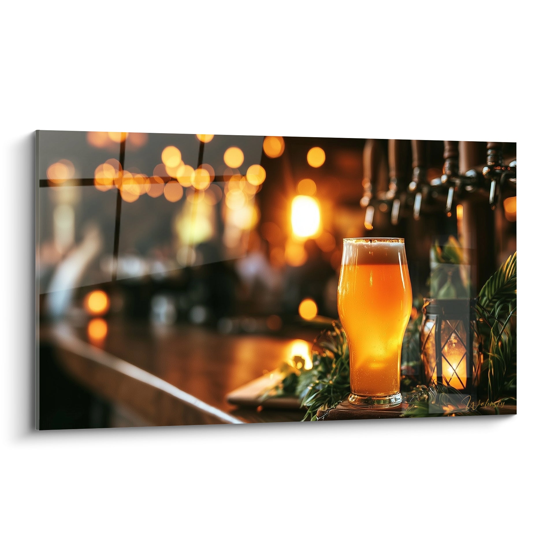 Verre de bière ambrée et doré posé sur comptoir brun, becs de tireuse anthracite en fond flou