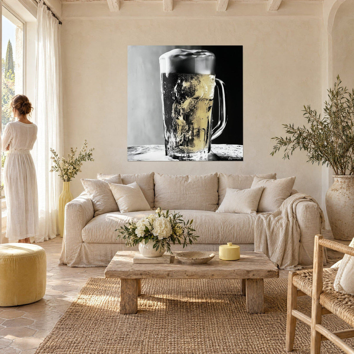 Tableau chope de bière givrée à la mousse épaisse, reflets dorés sur fond noir et gris, au-dessus d'un canapé dans un salon lumineux