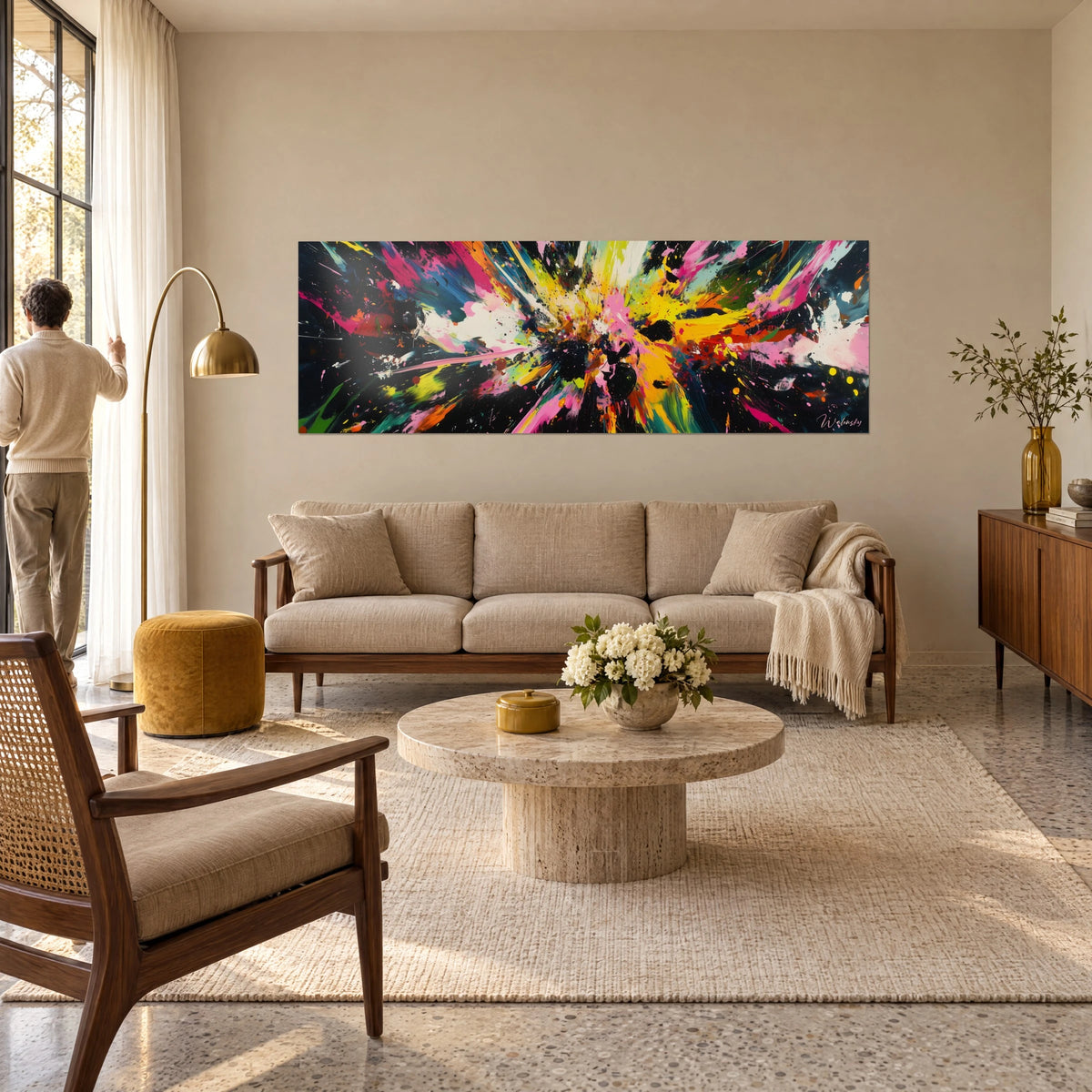 Tableau explosion de peinture rose, jaune et noire aux éclaboussures vives, au-dessus d'un canapé dans un salon lumineux