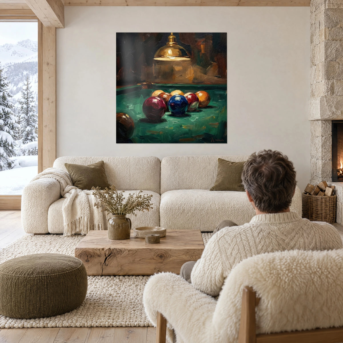 Schilderij biljarttafel met bordeaux- en nachtblauwe ballen onder een gouden lamp, persoon met de rug naar de kijker, boven een bank in een lichte woonkamer
