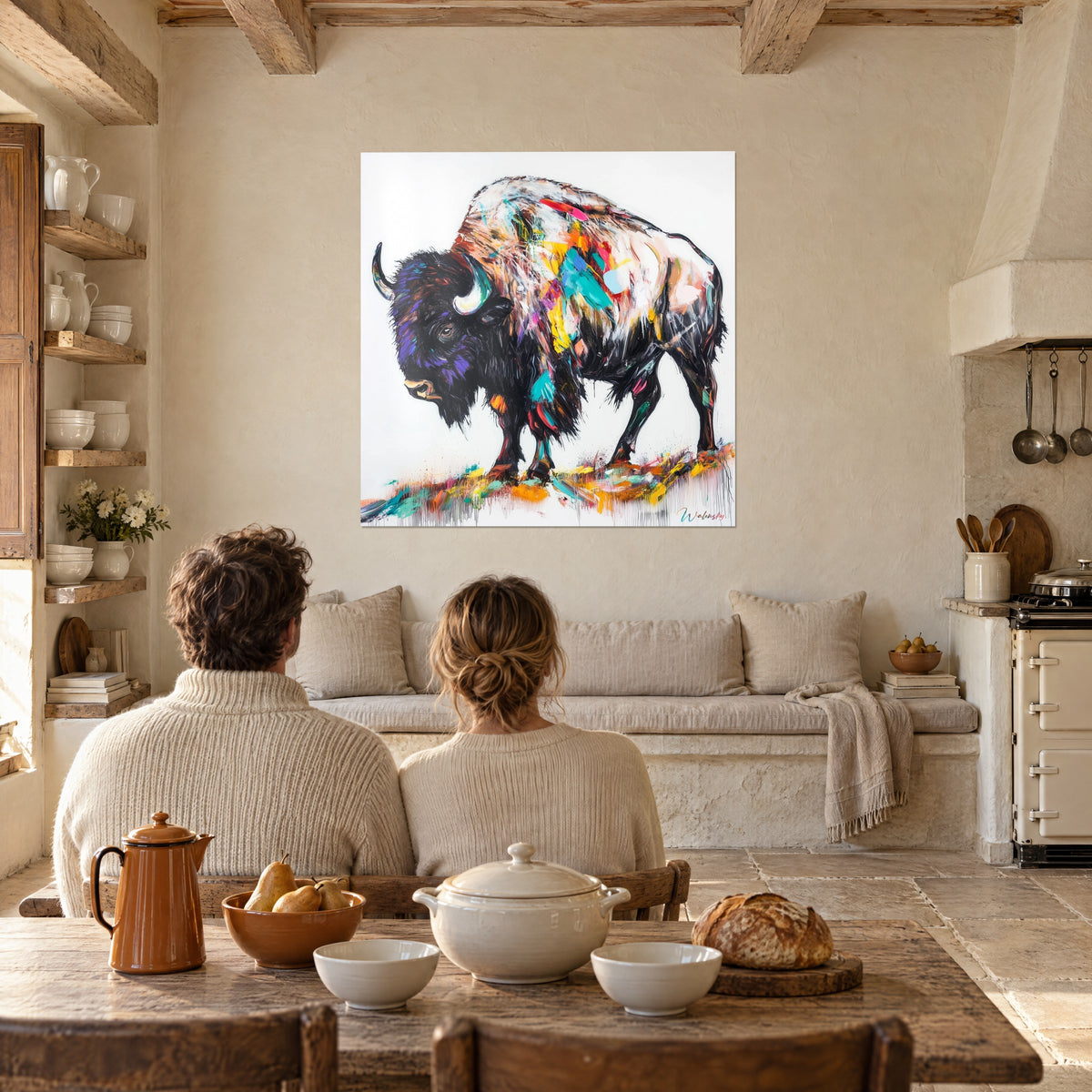 Cuadro de un gigantesco bisonte de las llanuras con cuernos marfil y pelaje negro violáceo, admirado desde la mesa de un rincón rústico de comedor