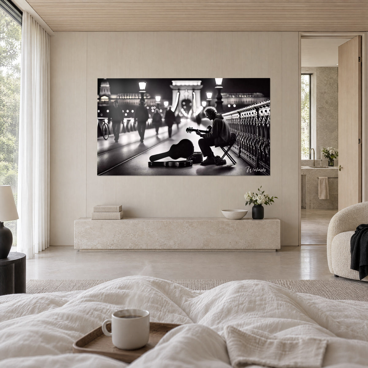 Cuadro de un artista callejero con sudadera gris, puente colgante iluminado en blanco y negro, encima de una cama en un dormitorio luminoso