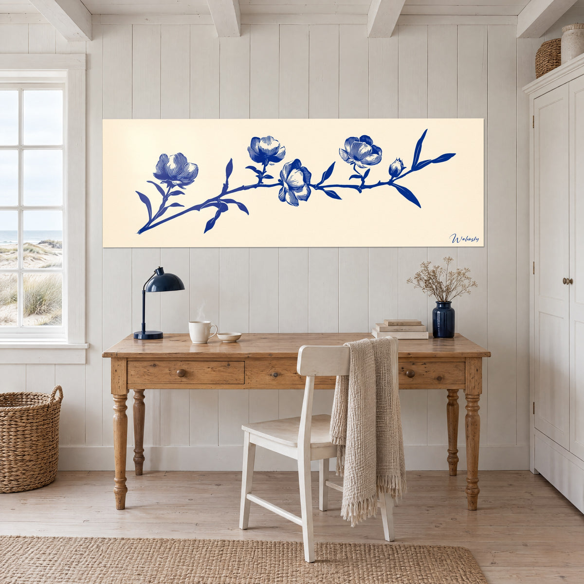 Schilderij van een bloeiende tak in koningsblauwe gravure op ivoor, opgehangen boven een bureau van licht hout met een nachtblauwe lamp