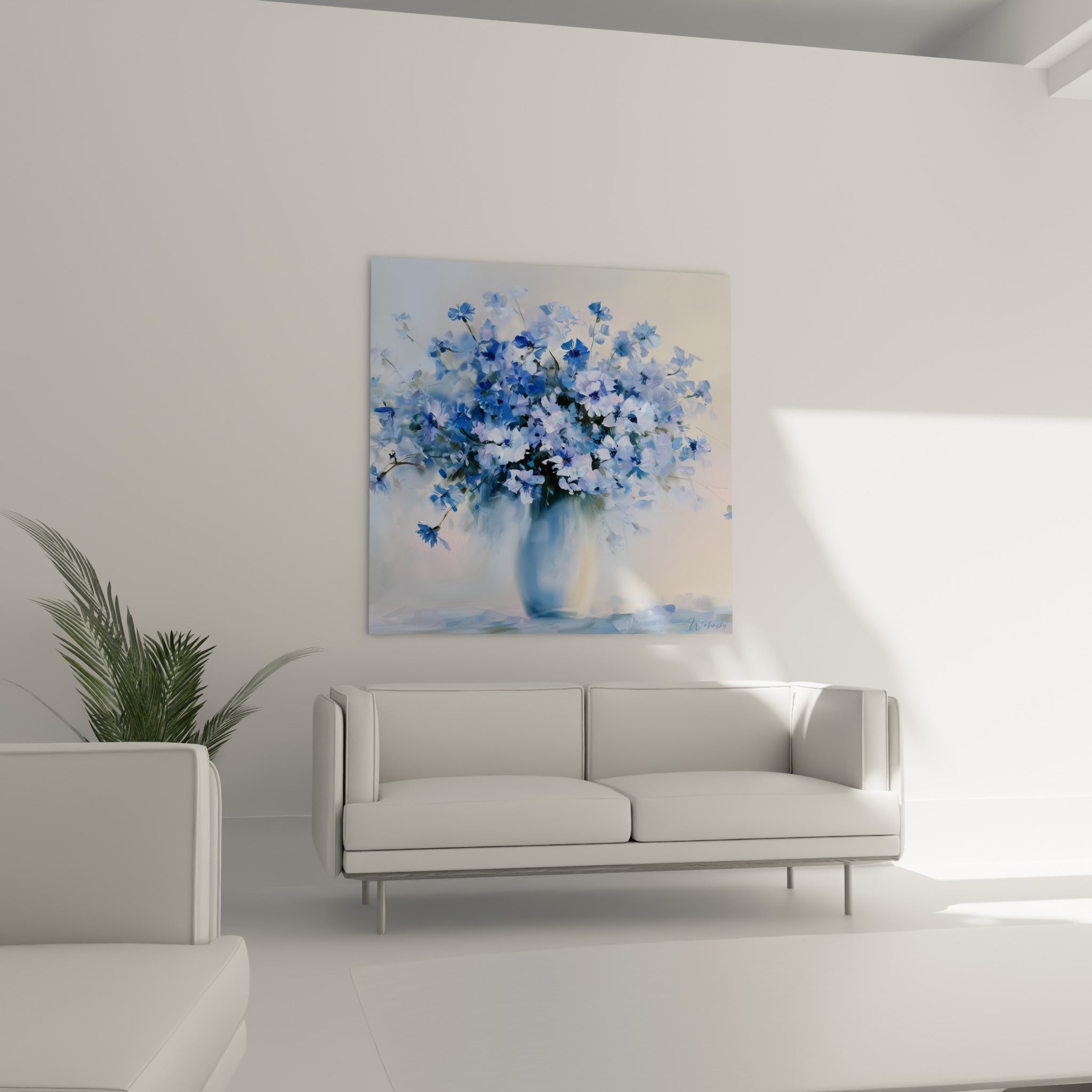 Vase de bleuets bleu marine et rosé, composition florale suspendue au-dessus d'un canapé dans un salon lumineux