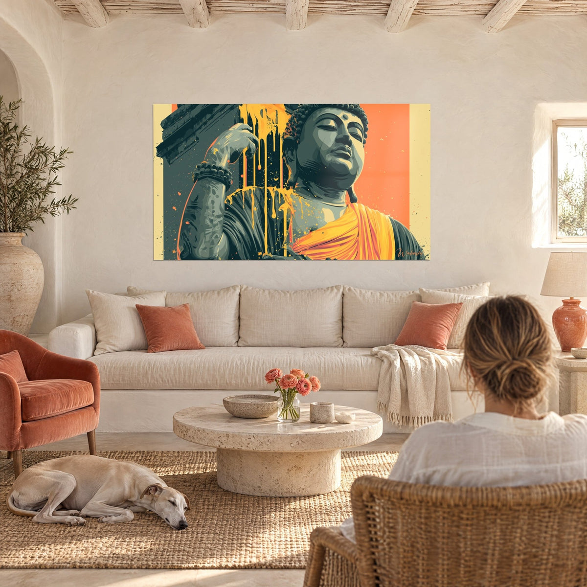 Tableau statue de Bouddha anthracite aux coulures dorées, drapé orange, fond corail, au-dessus d'un canapé dans un salon lumineux