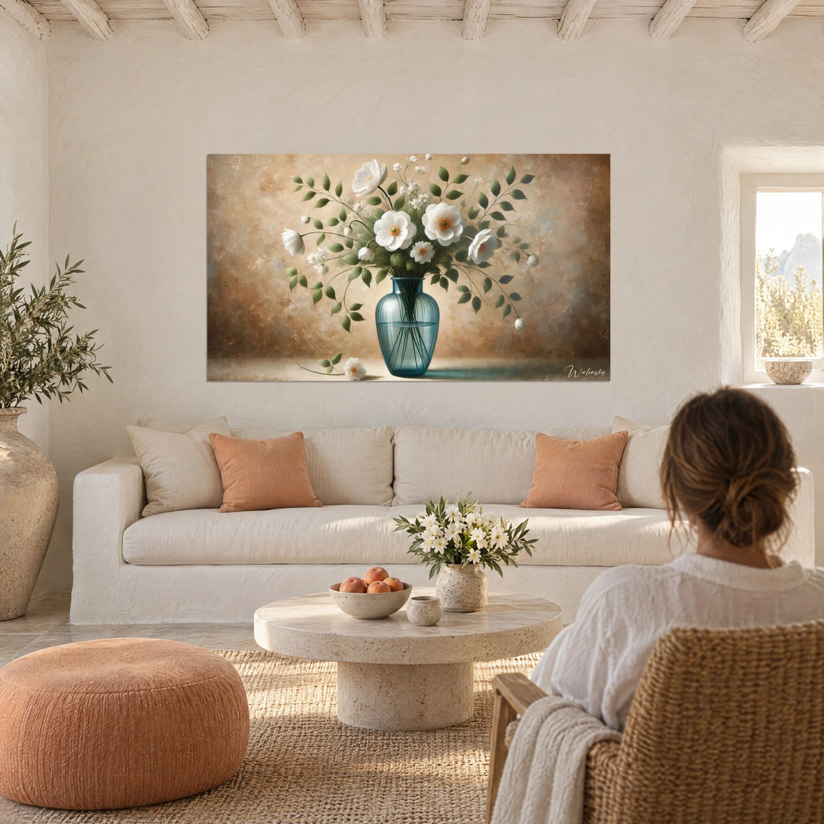Tableau bouquet d'anémones blanches dans un vase bleu-vert, fond beige cuivré, au-dessus d'un canapé dans un salon lumineux
