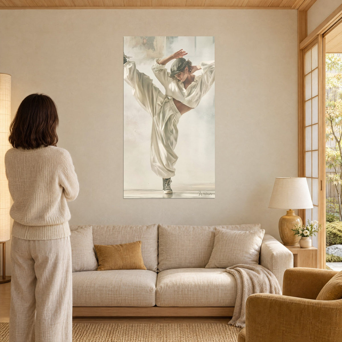Tableau danseuse en casquette grise, jambe levée dans un pantalon crème ample, fond brumeux, au-dessus d'un canapé dans un salon lumineux