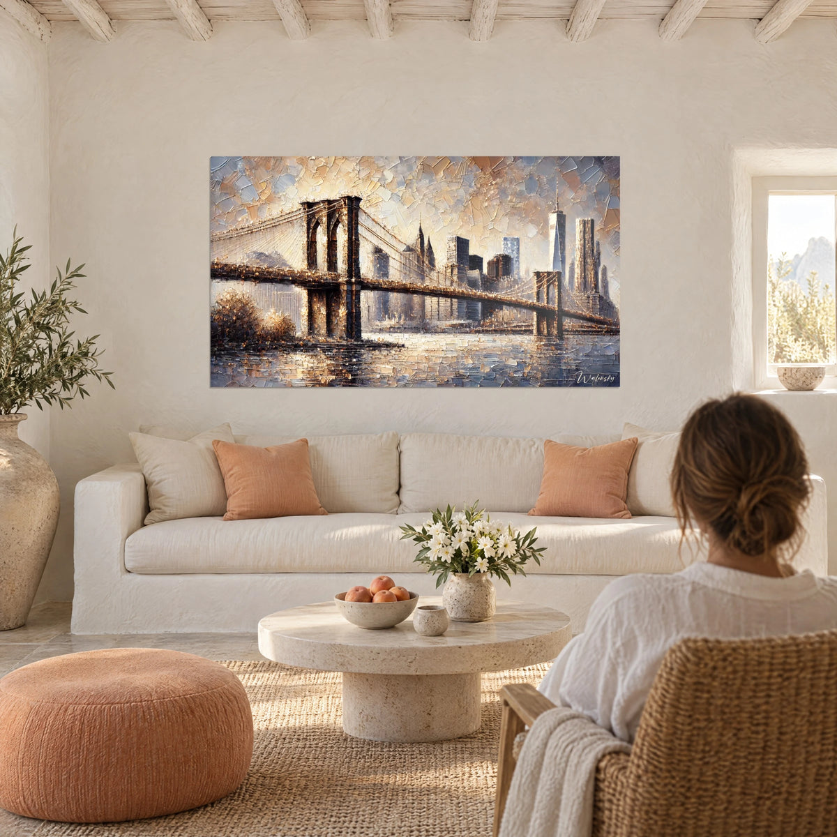 Quadro ponte di Brooklyn in ocra e blu acciaio, pennellate spesse a spatola, una donna di spalle, sopra un divano in un soggiorno luminoso