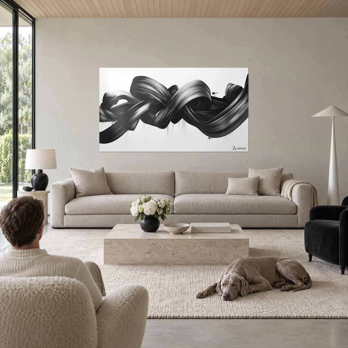 Tableau ruban de peinture noir entrelacé, reflets argentés sur fond blanc, coulures fines, au-dessus d'un canapé dans un salon lumineux