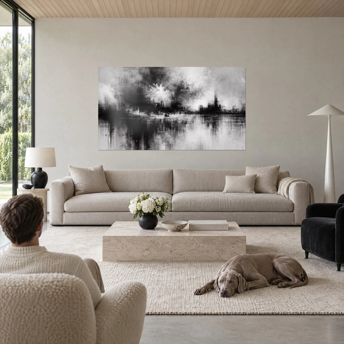 Wall art ghost skyline shrouded in mist, charcoal black and pearl grey, reflections on water, above a sofa in a bright living room