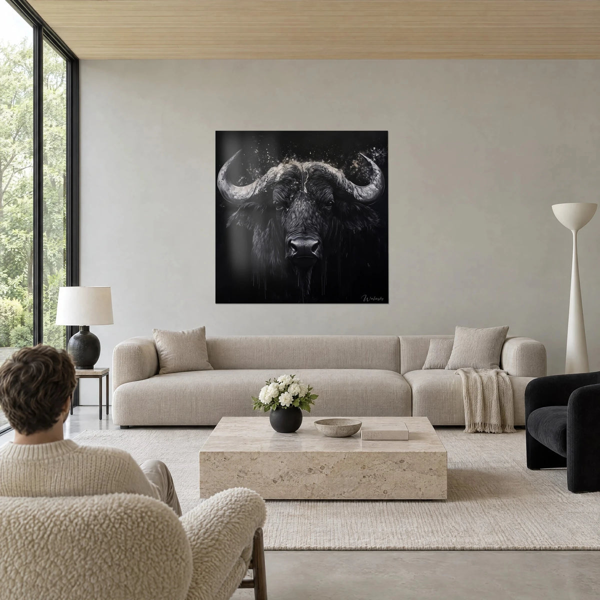 Gemälde Schwarzer Büffel mit silbrigen, pulverbestäubten Hörnern, ein Mann von hinten, über einem Sofa in einem hellen Wohnzimmer