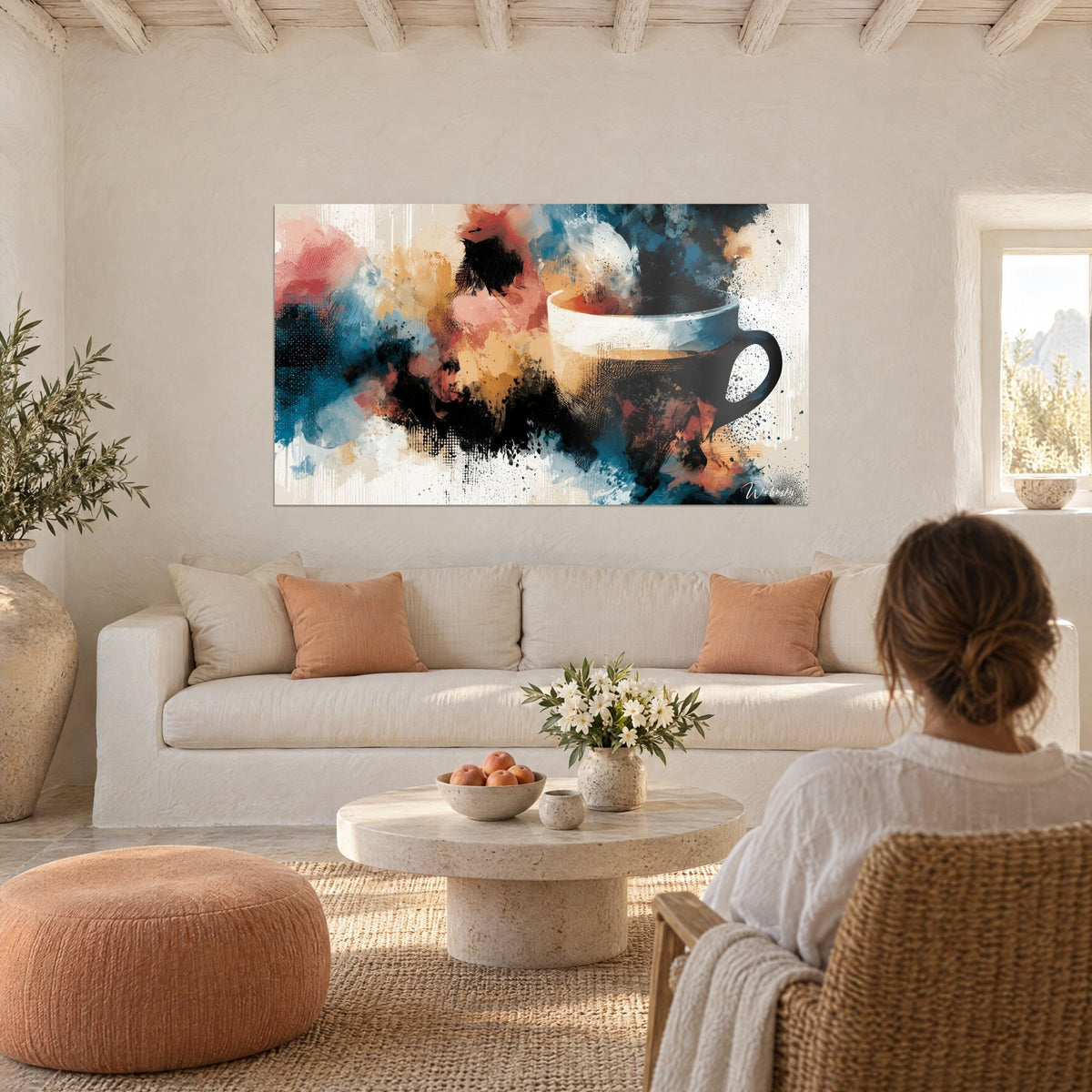 Quadro Tazza bianca cerchiata di blu, schizzi corallo e ocra, donna di spalle, sopra un divano in un soggiorno luminoso