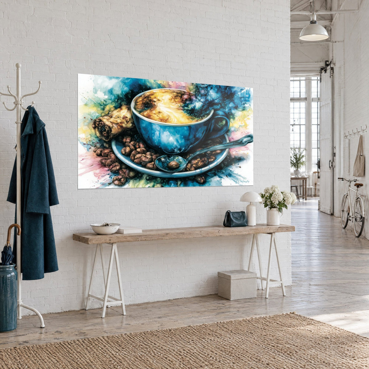 Quadro caffè cremoso ocra nella sua tazza indaco, cucchiaino argentato e spruzzi rosa e gialli, parete bianca di un loft