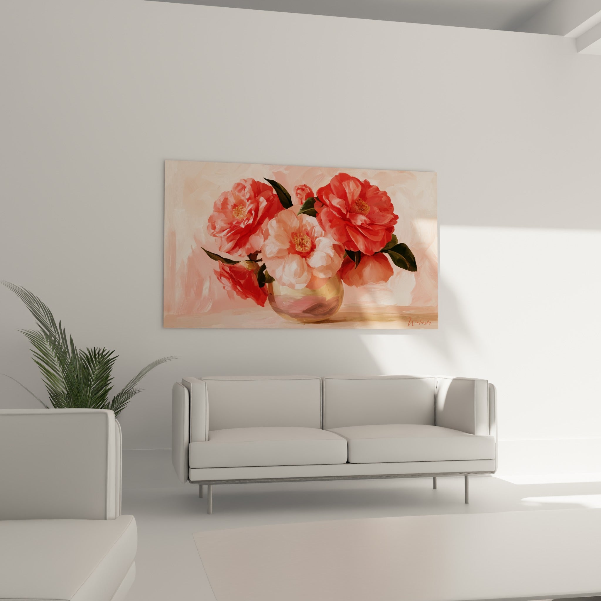 Bouquet de camélias rouge vermillon et rose dans un vase bronze, au-dessus d'un canapé dans un salon lumineux
