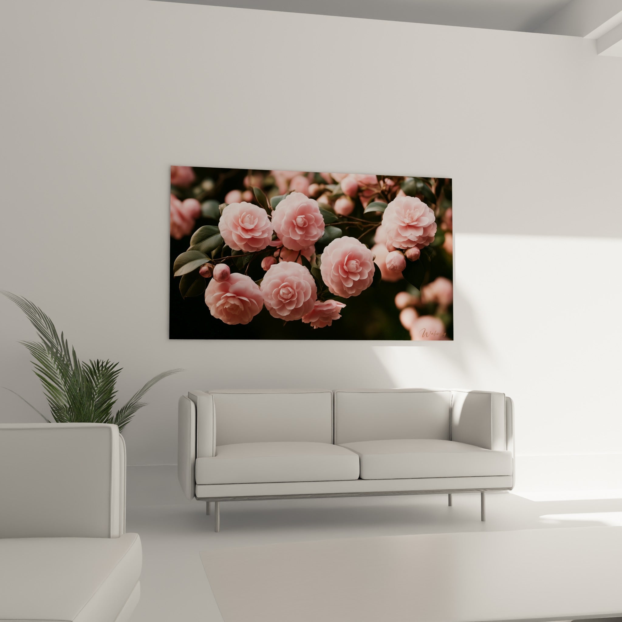 Bouquet de camélias roses et feuilles olive suspendu au-dessus d'un canapé dans un salon lumineux