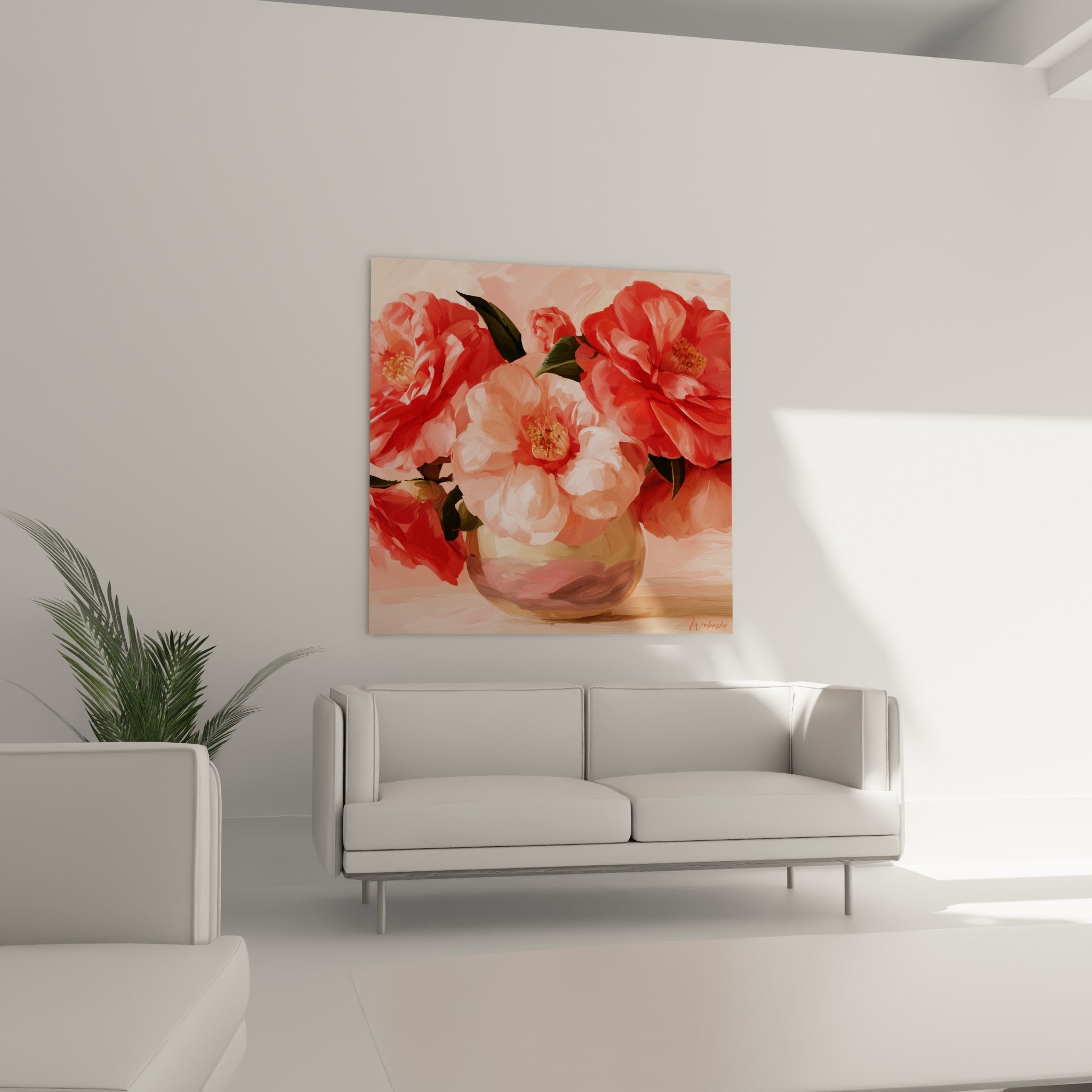 Camélias rouge corail et rose pâle en vase doré, au-dessus d'un canapé dans un salon lumineux