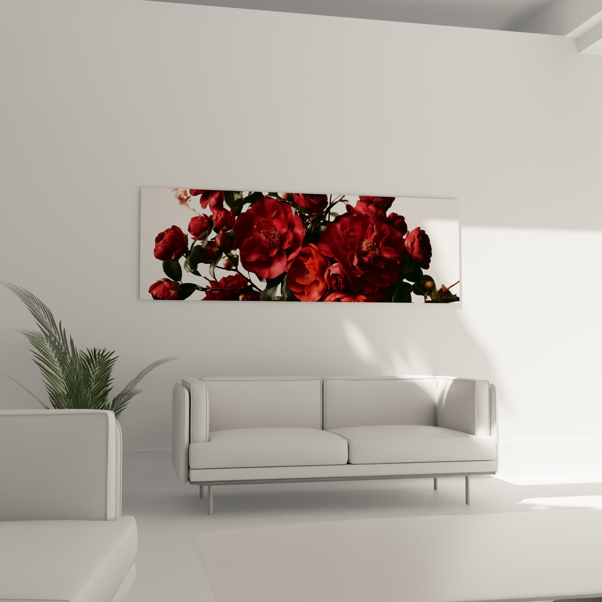 Fleurs de camélia bordeaux et feuillage vert profond au-dessus d'un canapé dans un salon lumineux