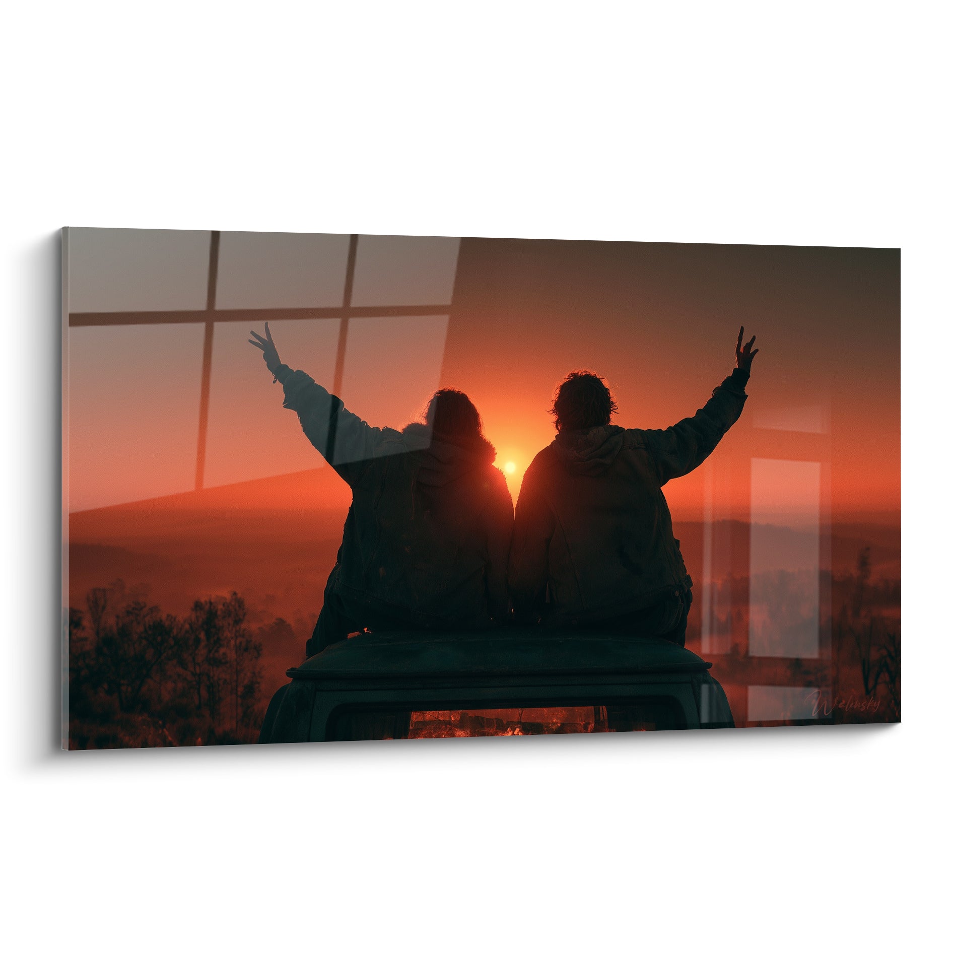 Couple silhouette noire bras levés sur van, ciel orange et rouge fauve au coucher de soleil