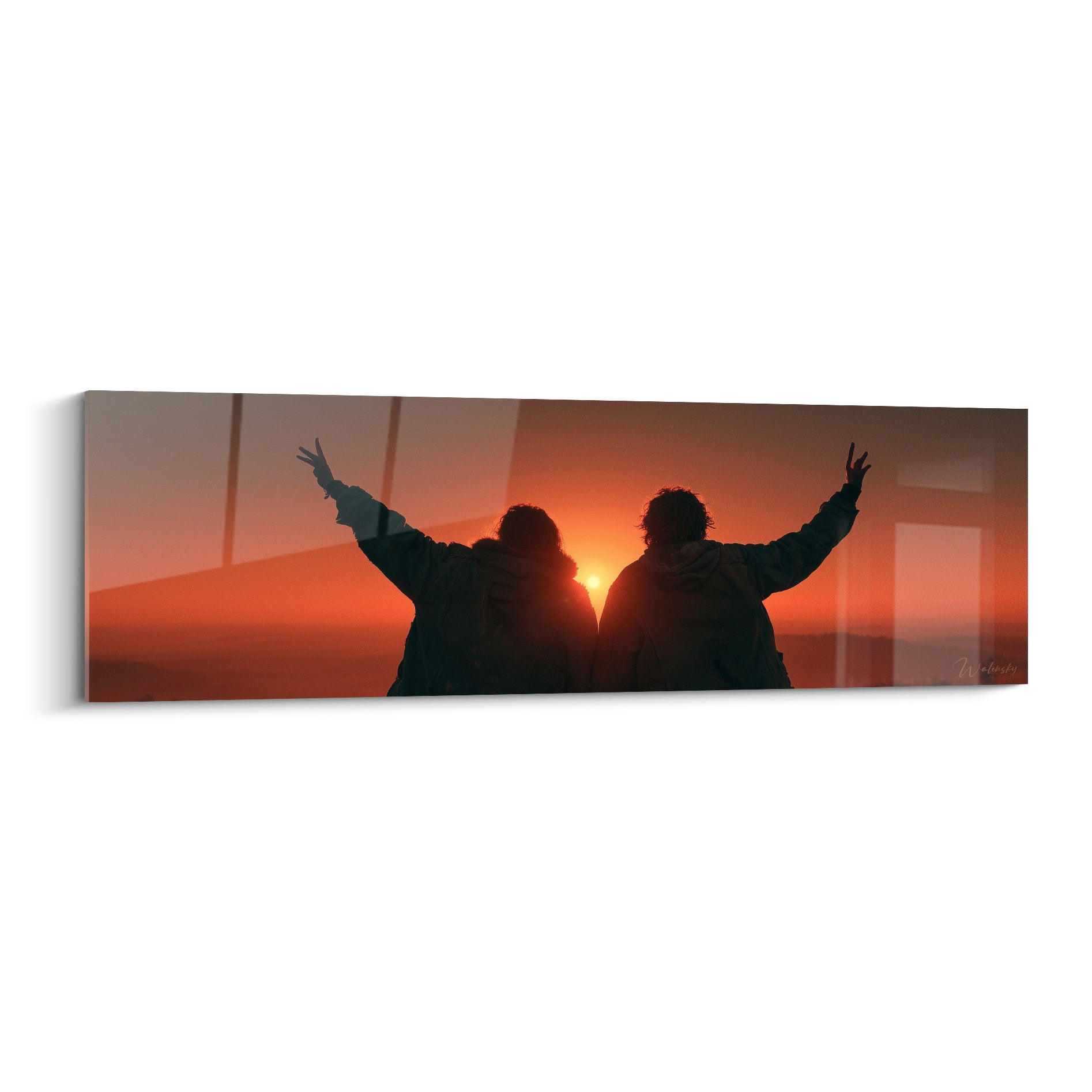 Deux silhouettes noires bras levés face à un coucher de soleil orange et brun intense