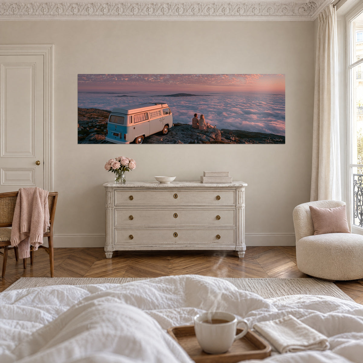 Schilderij van een retro camper op de rots, een oceaan van zalmroze en lavendelkleurige wolken onder een pastelhemel, boven een bed in een lichte slaapkamer